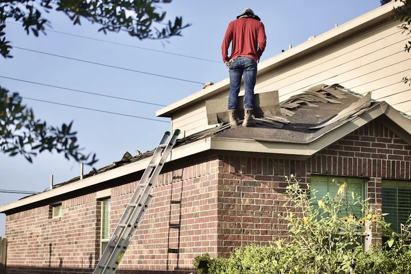 Professional roofer working on a residential roof in Damson-Logan